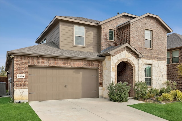 view of front of house with central air condition unit, a garage, and a front yard