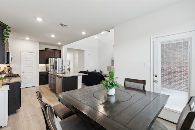 dining area with sink and light hardwood / wood-style floors