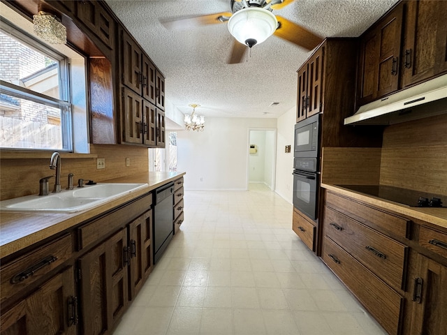 kitchen featuring black appliances, sink, a textured ceiling, decorative light fixtures, and a chandelier