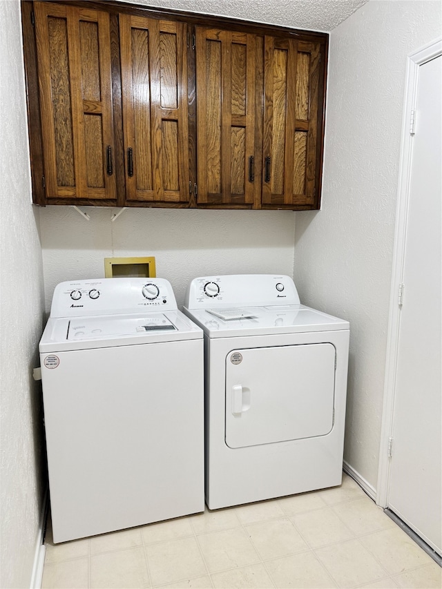 laundry room with cabinets, independent washer and dryer, and a textured ceiling