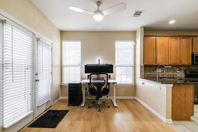 home office with ceiling fan, sink, and light hardwood / wood-style flooring