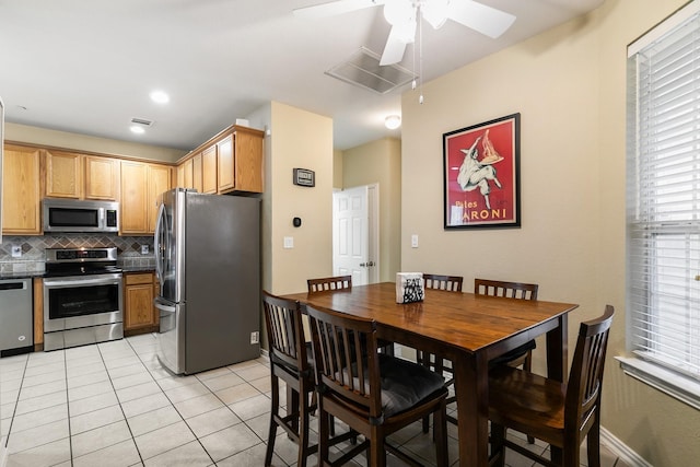 kitchen with tasteful backsplash, light tile patterned floors, stainless steel appliances, and ceiling fan