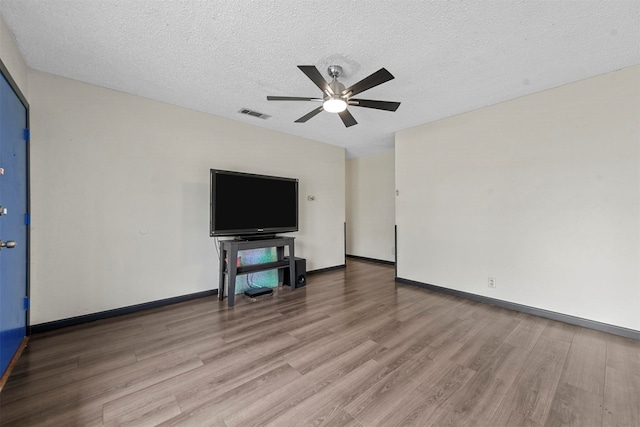 unfurnished living room featuring light hardwood / wood-style floors, ceiling fan, and a textured ceiling