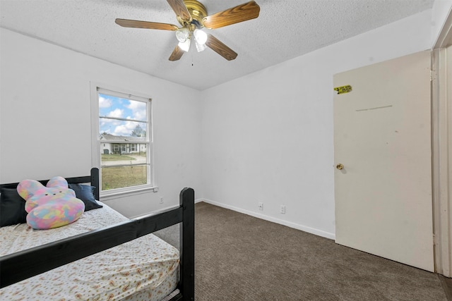 bedroom featuring ceiling fan, a textured ceiling, and dark carpet