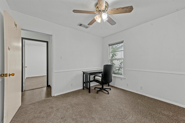 carpeted office space featuring a textured ceiling and ceiling fan