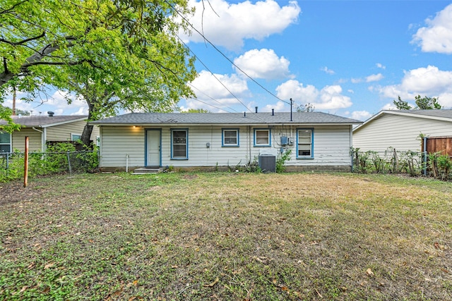 rear view of house with a lawn and central AC