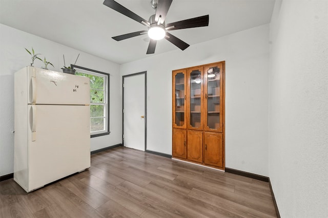 kitchen with light hardwood / wood-style floors, ceiling fan, and white fridge