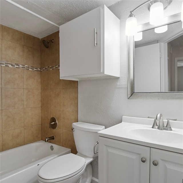 full bathroom with vanity, tiled shower / bath, toilet, and a textured ceiling