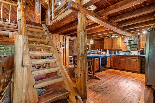 staircase with beamed ceiling, wood ceiling, wood-type flooring, and bar