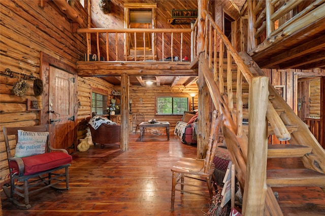 interior space featuring rustic walls, wood-type flooring, and a high ceiling