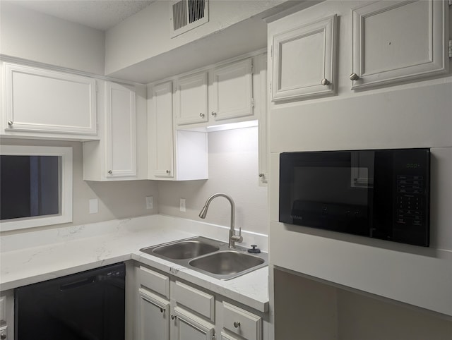 kitchen featuring white cabinetry, a textured ceiling, black appliances, and sink