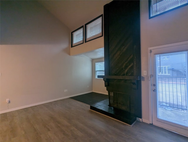 unfurnished living room with dark wood-type flooring and high vaulted ceiling