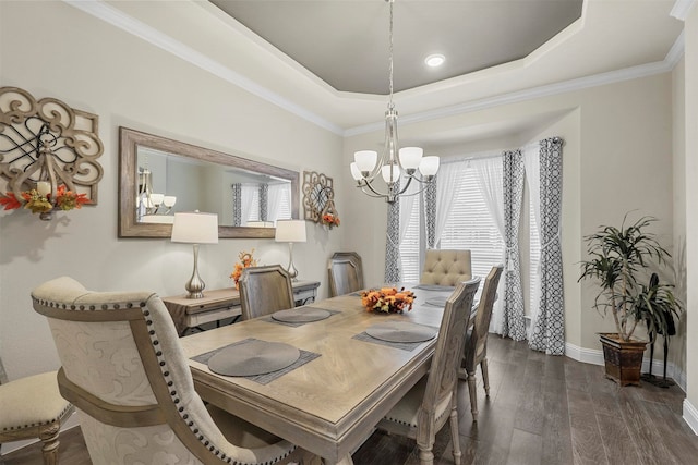 dining space with dark hardwood / wood-style flooring, a chandelier, crown molding, and a raised ceiling