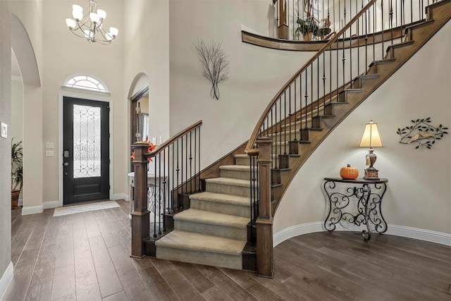 entrance foyer with dark wood-type flooring, a chandelier, and a high ceiling