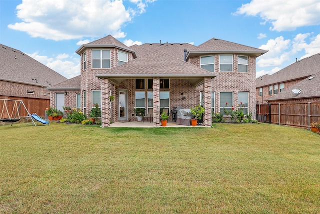 rear view of house with a yard and a patio area