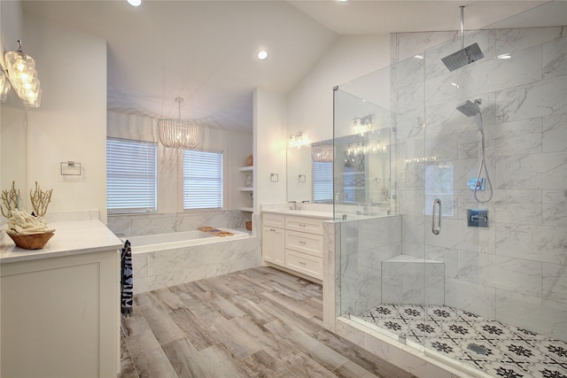 bathroom with hardwood / wood-style flooring, vanity, vaulted ceiling, independent shower and bath, and a chandelier