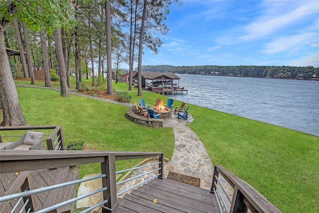 dock area with a water view, an outdoor fire pit, and a yard