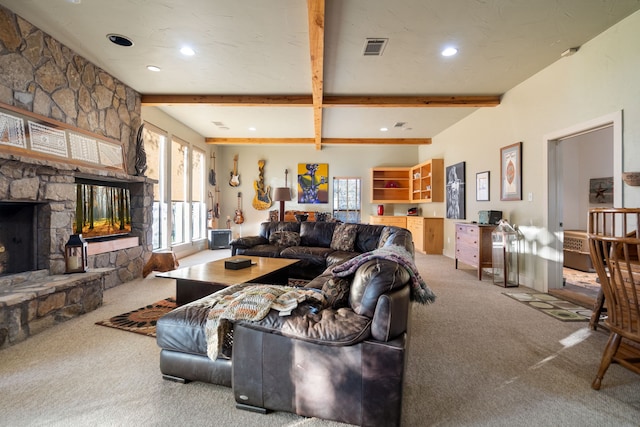 living room with beamed ceiling, carpet, and a stone fireplace