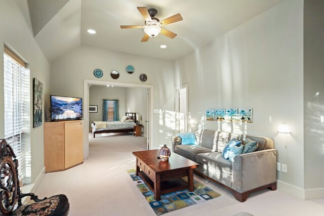 living room featuring ceiling fan, light colored carpet, and lofted ceiling