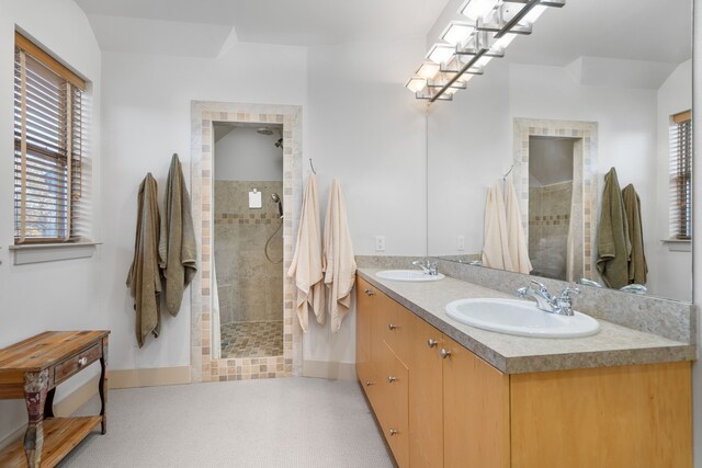 bathroom featuring a tile shower and vanity