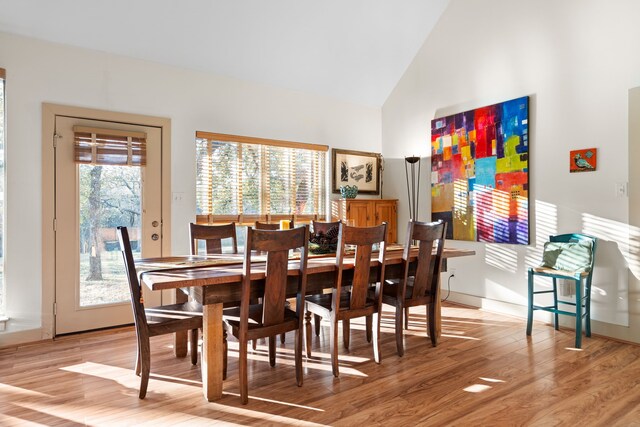 dining room with hardwood / wood-style floors and high vaulted ceiling