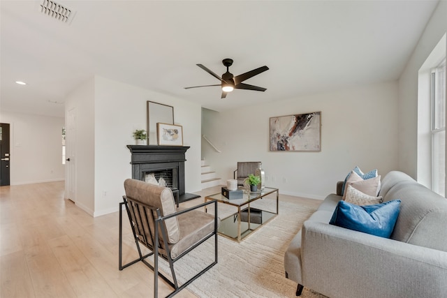 living room with light wood-type flooring and ceiling fan