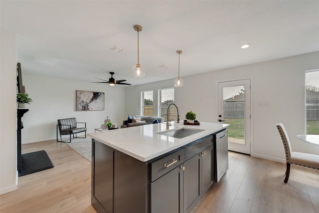 kitchen with sink, a kitchen island with sink, dishwasher, and light hardwood / wood-style flooring