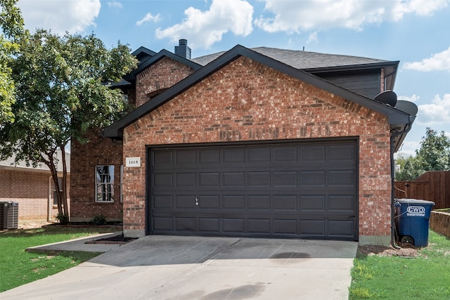 view of front facade with a garage and central AC