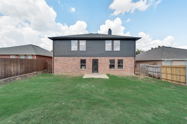 rear view of house with a patio and a lawn