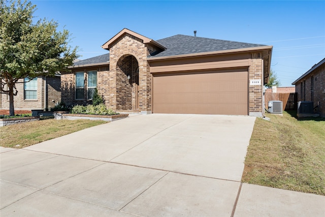 single story home with central AC unit, a garage, and a front lawn