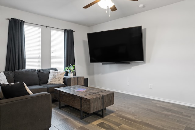 living room featuring ceiling fan and dark wood-type flooring