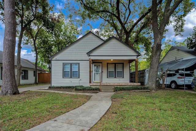 bungalow-style house featuring covered porch and a front lawn