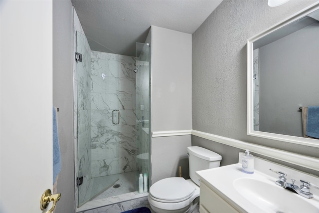 bathroom with vanity, a textured ceiling, toilet, and a shower with door