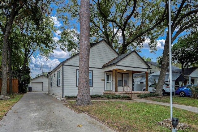 bungalow-style home featuring an outbuilding, a garage, a front lawn, and a porch