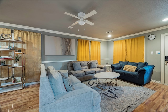 living room with a textured ceiling, wood-type flooring, ceiling fan, and crown molding