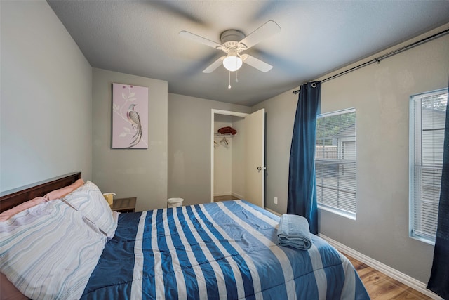 bedroom with a textured ceiling, hardwood / wood-style floors, and ceiling fan