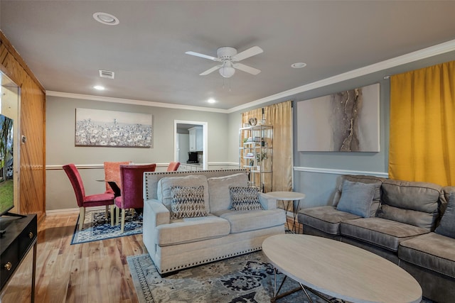 living room with light hardwood / wood-style flooring, ceiling fan, and crown molding