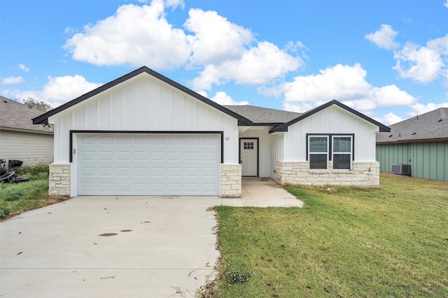 view of front of property featuring a garage, a front yard, and central air condition unit