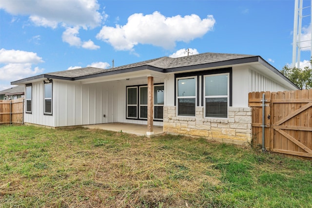 rear view of house featuring a yard and a patio