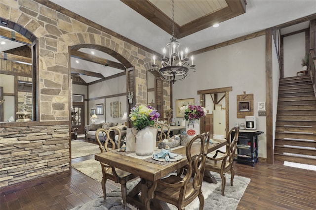 dining space with dark hardwood / wood-style flooring, beamed ceiling, a notable chandelier, and a high ceiling