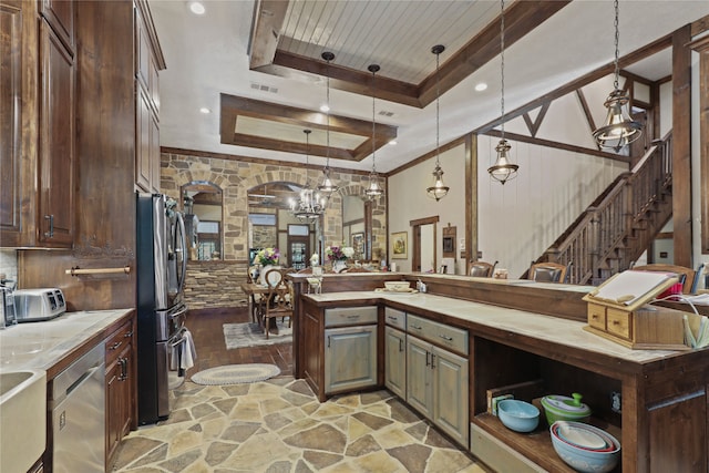 kitchen featuring stainless steel appliances, decorative light fixtures, a tray ceiling, dark brown cabinets, and light hardwood / wood-style flooring