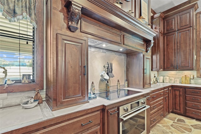 kitchen with backsplash, stainless steel oven, and black electric stovetop