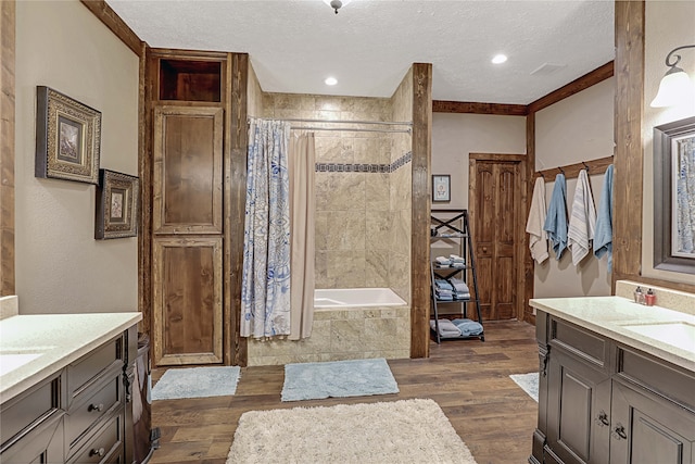 bathroom with ornamental molding, vanity, shower with separate bathtub, a textured ceiling, and hardwood / wood-style flooring