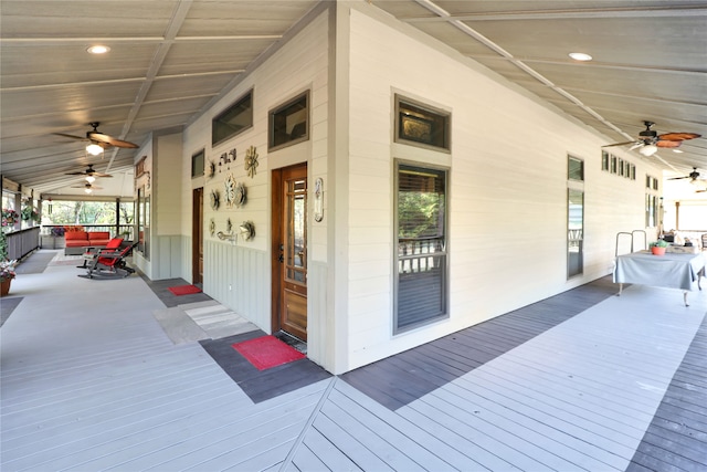 wooden deck featuring covered porch and ceiling fan