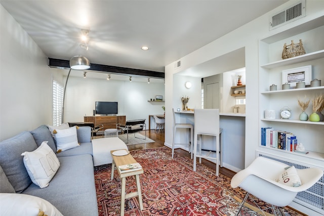 living room with hardwood / wood-style flooring, rail lighting, and built in shelves