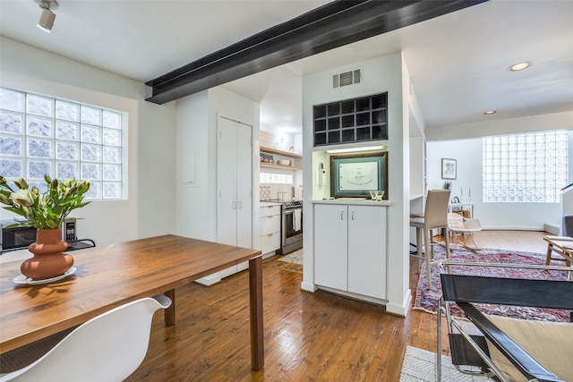 kitchen with dark wood-type flooring, white cabinets, a healthy amount of sunlight, and stainless steel electric stove