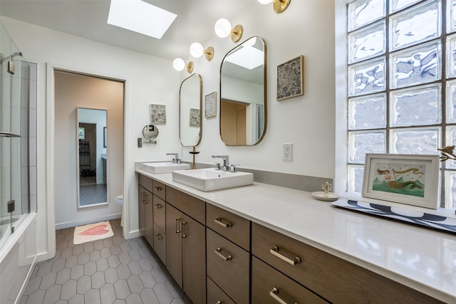 full bathroom featuring enclosed tub / shower combo, toilet, tile patterned floors, vanity, and a skylight