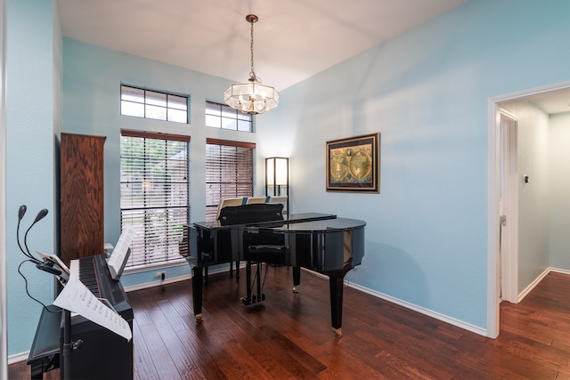 miscellaneous room featuring dark wood-type flooring and a chandelier