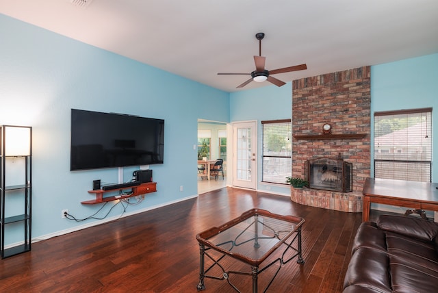 living room featuring hardwood / wood-style floors, ceiling fan, and a brick fireplace