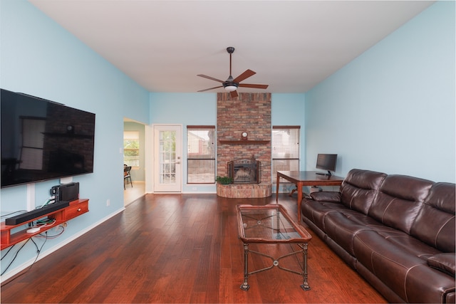 living room with dark wood-type flooring, a fireplace, and ceiling fan